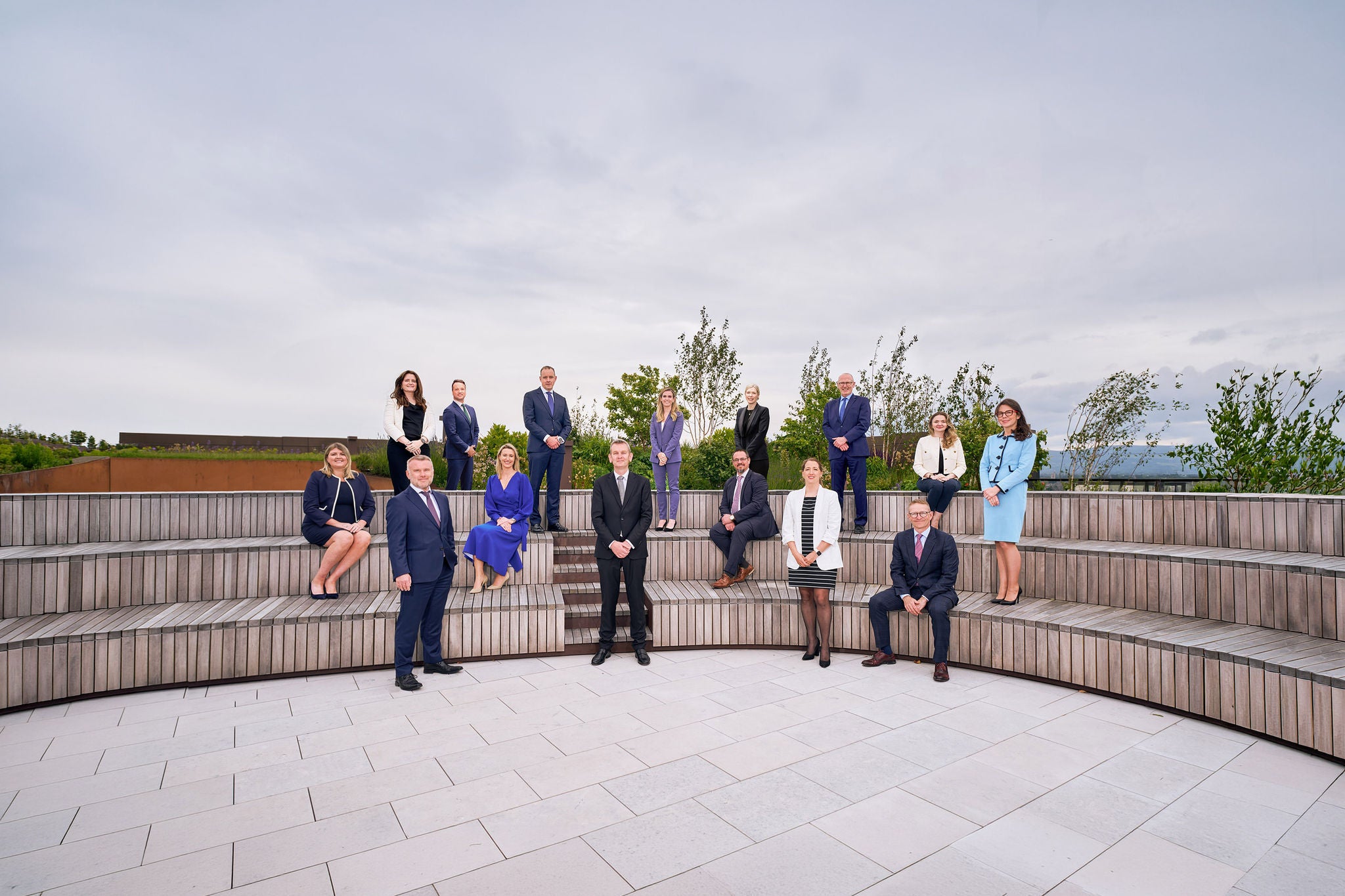 EY Law Partners posing for a group portrait on outdoor tiered seating.