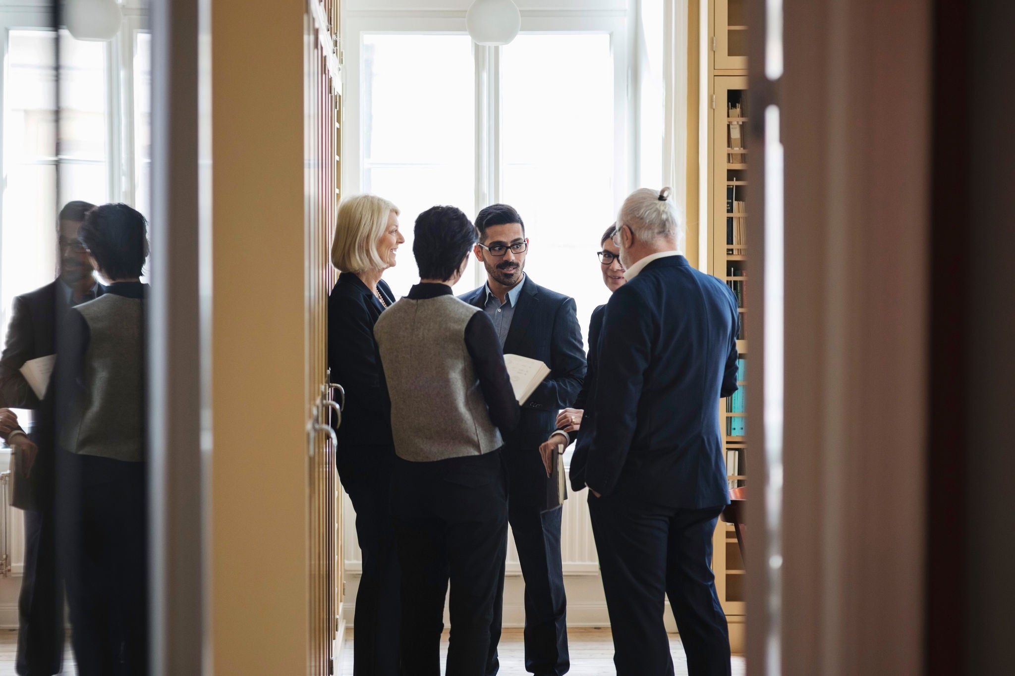 A group of professionals engaged in a discussion in a well-lit office.